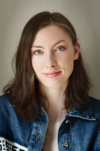 Subtelny portret kobiety w dżinsowej kurtce, z delikatnym makijażem i spokojnym wyrazem twarzy