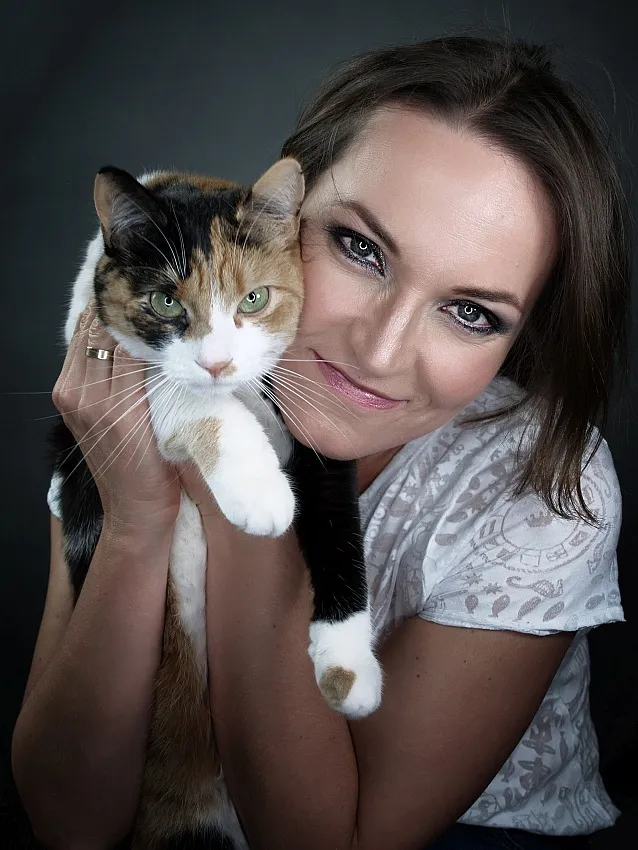 Kobieta przytulająca kota, oboje patrzą prosto w obiektyw, ciepły i emocjonalny portret